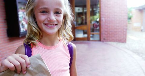 Smiling Schoolgirl Holding Paper Bag on School Campus - Download Free Stock Images Pikwizard.com
