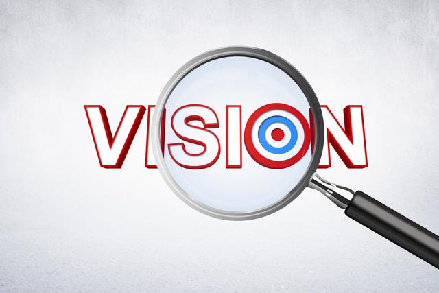 Digital composite of magnifying glass showing the word vision