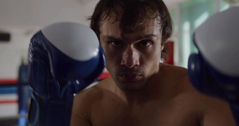 Determined Male Boxer Taking Fighting Stance in Training