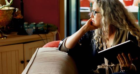 Mature Woman in Thought Holding Tablet at Home - Download Free Stock Images Pikwizard.com