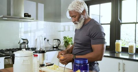 Healthy Lifestyle: Senior Man Preparing Smoothie in Modern Kitchen
