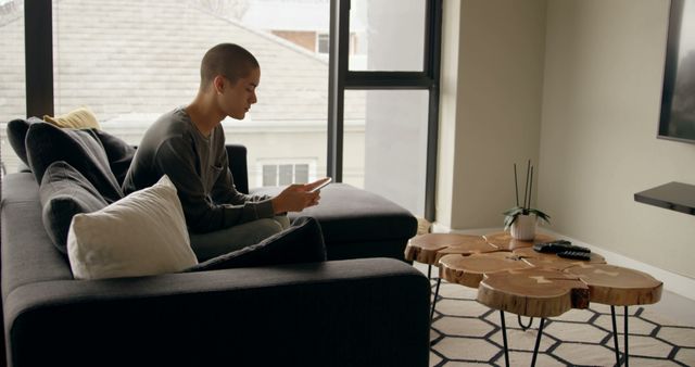 Person Relaxing on Couch Using Smartphone in Modern Living Room - Download Free Stock Images Pikwizard.com