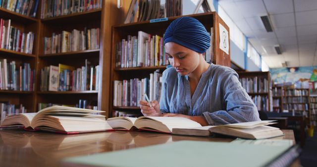 Focused Student Wearing Head Wrap Studying in Library - Download Free Stock Images Pikwizard.com