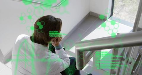 Contemplative scientist sitting on stairwell with green augmented-reality biotech overlay