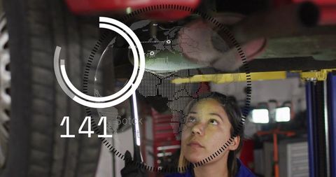 Female mechanic inspecting undercarriage on lift holding inspection light with hud overlay
