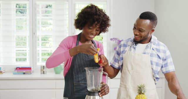 Happy couple preparing smoothie in bright modern kitchen - Download Free Stock Images Pikwizard.com