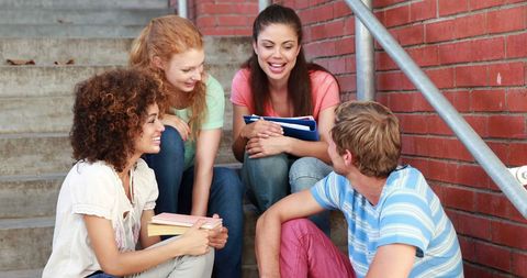 cheerful students chatting on campus steps with books - Download Free Stock Images Pikwizard.com