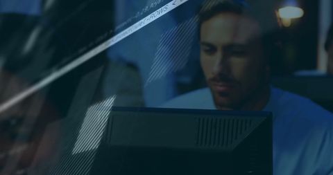 Businessman Analyzing Financial Data on Computer at Night