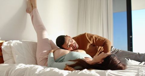 Expecting Couple Enjoying Romantic Moment on Bed