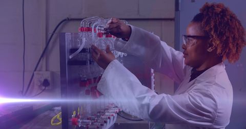 Scientist with afro hair in laboratory analyzing equipment