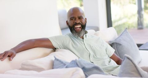 Man Laughing Relaxed on Couch at Home - Download Free Stock Images Pikwizard.com