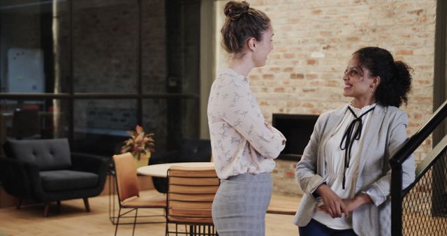 Two Women Having Casual Conversation in Modern Office Space - Download Free Stock Images Pikwizard.com