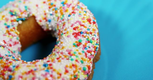 Close-up of Colorful Donut with Sprinkles on Blue Background - Download Free Stock Images Pikwizard.com
