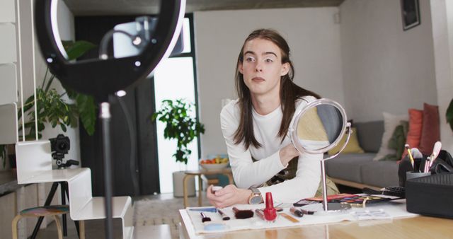 Caucasian non-binary transgender woman making make up image. spending quality time at home alone, body inclusivity.