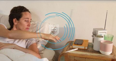 Woman Reaching for Alarm Clock on Rustic Bedside Table in Bedroom
