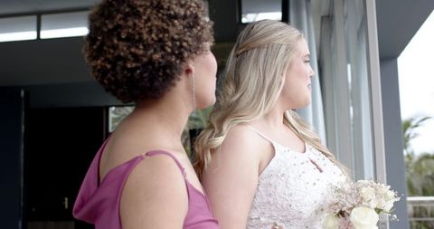 Bride and bridesmaid sharing moment before wedding ceremony