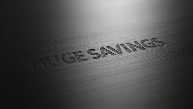 Embossed huge savings on brushed metal panel showing dramatic highlight and macro grain