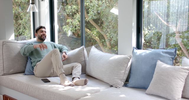 Relaxed Man Sitting on Comfortable Sofa in Sunlit Living Room - Download Free Stock Images Pikwizard.com