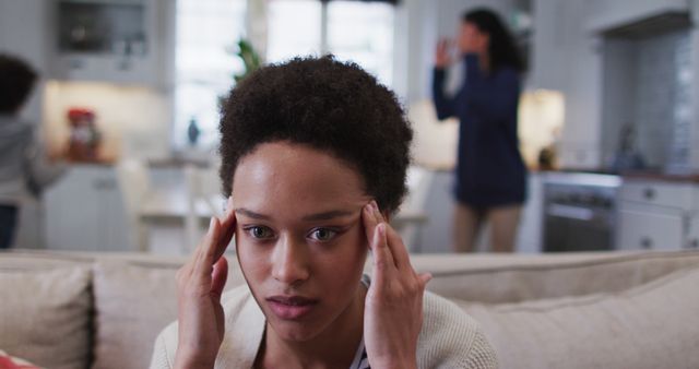 Woman in Living Room Looking Stressed with Family in Background - Download Free Stock Images Pikwizard.com