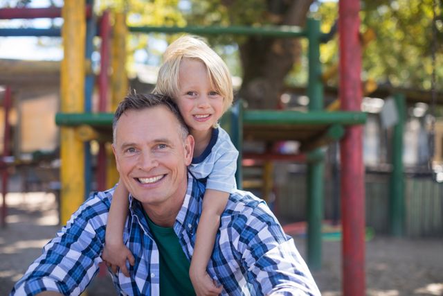 Father and son enjoying time together at a playground. Perfect for family-oriented advertisements, parenting blogs, and articles about father-son relationships. Can be used to promote outdoor activities, family bonding, and child development.