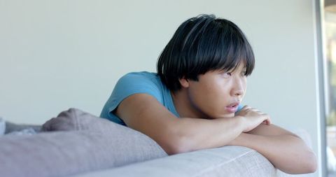 Thoughtful Young Asian Man Relaxing on Couch - Download Free Stock Images Pikwizard.com