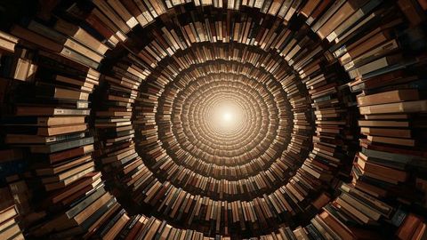 Spiraling bookshelf tunnel leading to bright center