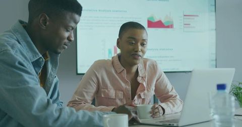 Professional Team Analyzing Data with Charts and Laptop