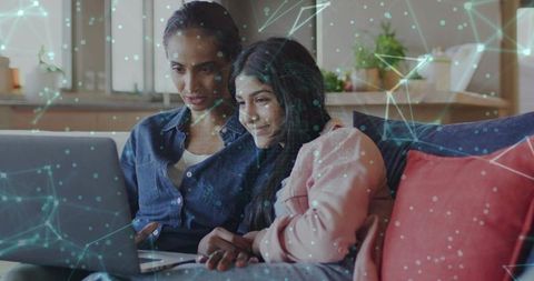 Mother and daughter sharing laptop on cozy sofa with network overlay for online learning