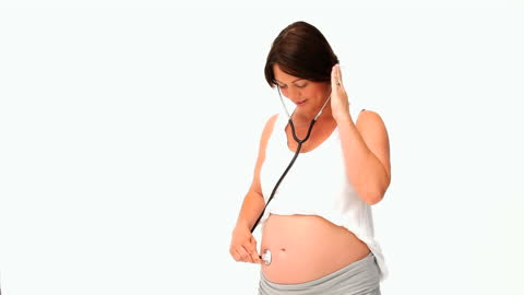Pregnant Woman Listening to Belly with Stethoscope Against White Background