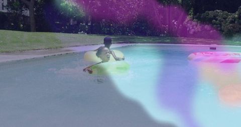 Siblings Enjoying Pool Fun with Inflatable Rings Outdoor