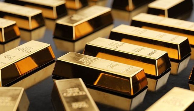 Polished gold bullion bars reflecting on glossy dark surface luxury wealth and investment concept