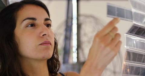 Female photographer checking film strips in studio