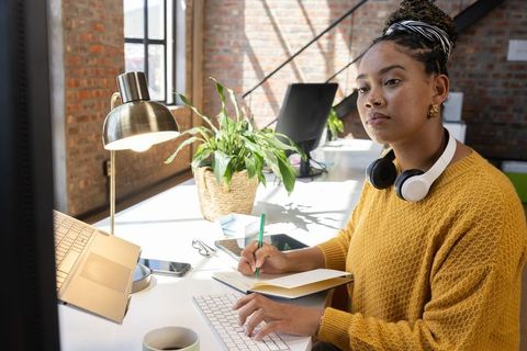 Young Professional Woman Working in Loft Office with Greenery