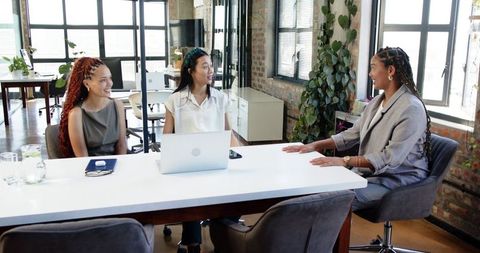 Diverse female team discusses success in modern office