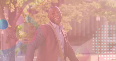 Joyful businessman laughing in sunlit atmosphere