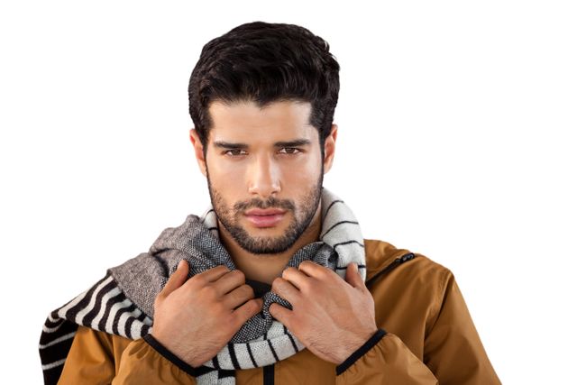 Young man posing confidently with a scarf, wearing casual outerwear. Ideal for fashion, lifestyle, and seasonal promotions. Perfect for use in advertisements, blogs, and social media posts focusing on men's fashion and style.