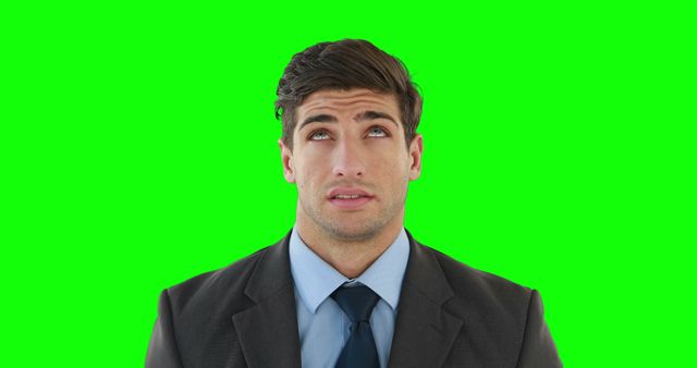 This image depicts a businessman in a suit and tie, showing a frustrated expression while rolling his eyes. The green screen background allows for easy editing and adding a custom backdrop. Perfect for use in presentations, advertisements, or projects needing a customizable human element showcasing stress or annoyance.