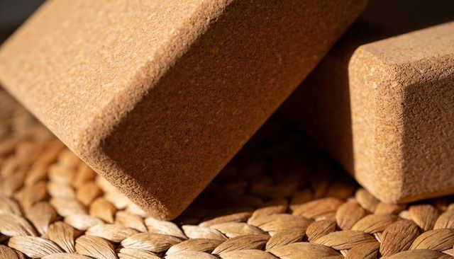 Showing cork yoga blocks resting on woven seagrass mat macro closeup warm texture
