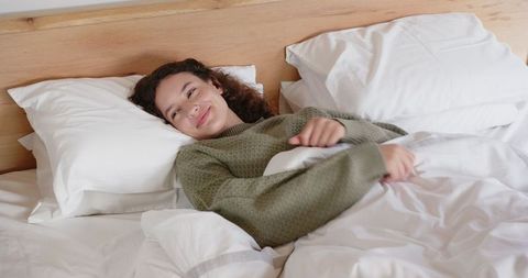 Young Woman Relaxing in Cozy Bedroom Environment Resting Comfortably