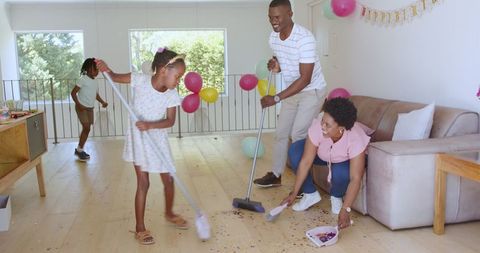 Family Cleaning Up After Party, Sweeping Floor and Tidying Room