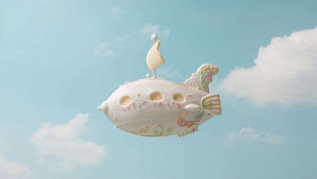 Whimsical pastel pastry airship with crescent sail and ornate tailfin floating in blue sky