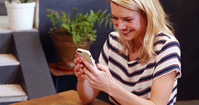 Smiling Woman Using Smartphone at Cafe Table - Download Free Stock Images Pikwizard.com