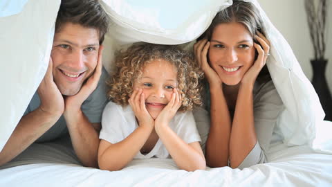 Happy Family Enjoying Time Together under Bedsheets