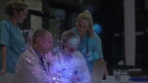 Medical Team Analyzing Data on Laptop with Digital Effects