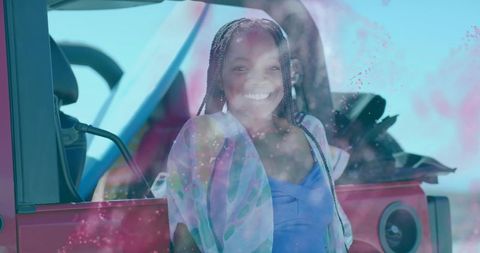 Smiling woman standing next to red suv outdoors