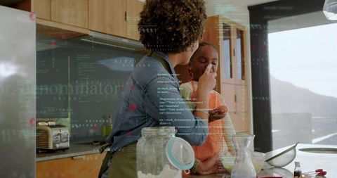 Caregiver feeding child in sunlit kitchen during baking and bonding with code overlay