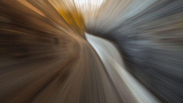 Swirling canyon motion curved pale stream cutting through radial blur tunnel abstract background