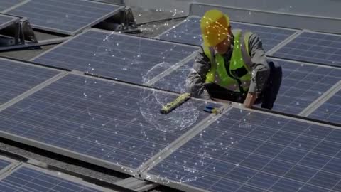 Technician Aligning Solar Panels on Rooftop with Data Overlay
