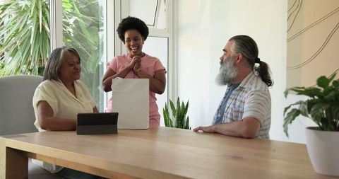 Senior Couple Receiving Gift from Family Member in Home Setting