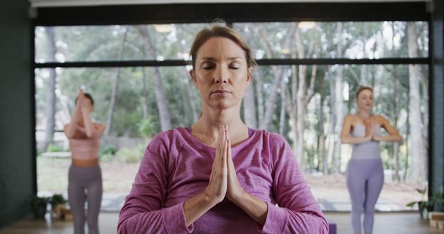 Middle-aged woman meditating in group yoga class - Download Free Stock Images Pikwizard.com